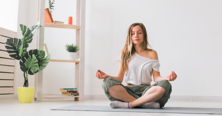 A woman meditating peacefully on a yoga mat in a clean, serene environment, embodying calm and mindfulness.